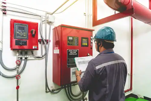 Technician reviewing a fire pump control panel