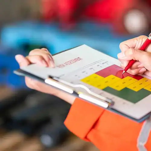 Inspector marking a risk assessment chart on a clipboard